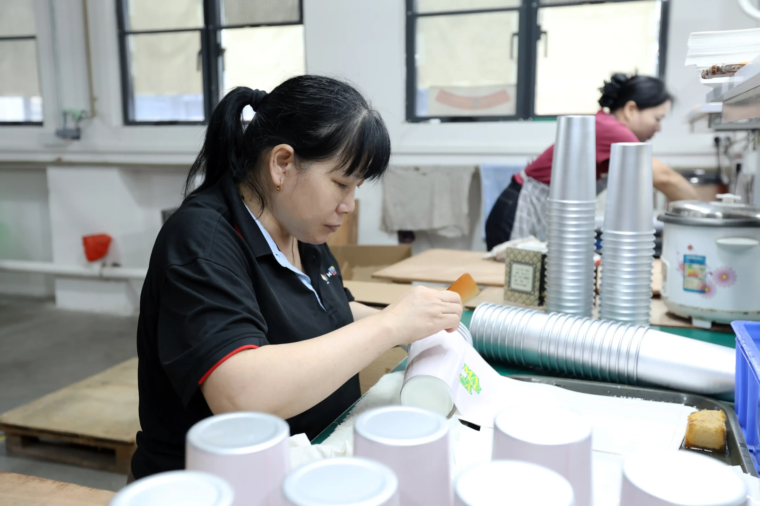Quality auditor conducting ASTM cross hatch tape adhesion test on printed graphic pattern